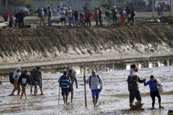 ười dân địa phương băng qua một con sông bị ngập lụt tại thị trấn Chanaral ngày 27/3