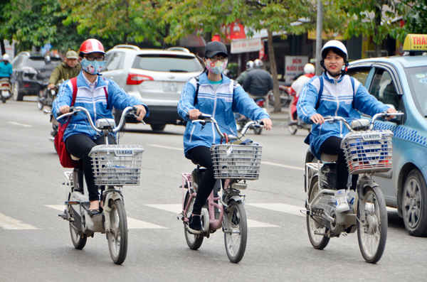 Ngồi trên xe đạp điện không mũ bảo hiểm dàn hàng 3 chiếm hết lòng đường.