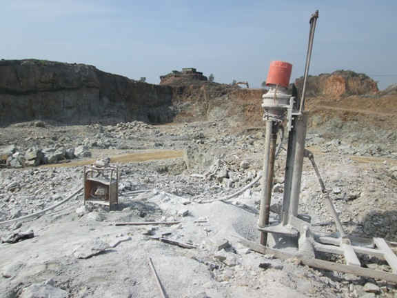Máy khoan đá chuẩn bị cho việc cài mìn tại khu vực khai thác