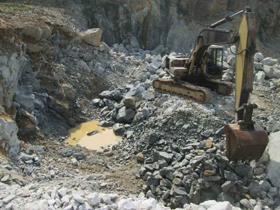 Máy múc, cùng nhiều thiết bị phục vụ cho việc khai thác đá đang trong tư thế hoạt động