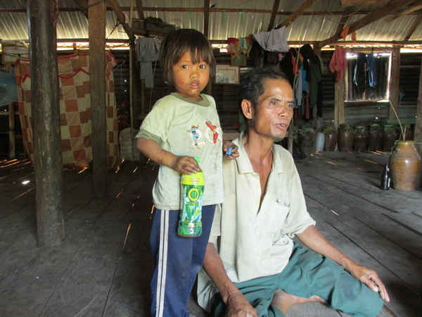 Ông Đinh Binh bên đứa cháu gái út đã mồ côi cả cha lẫn mẹ vì tự tử.