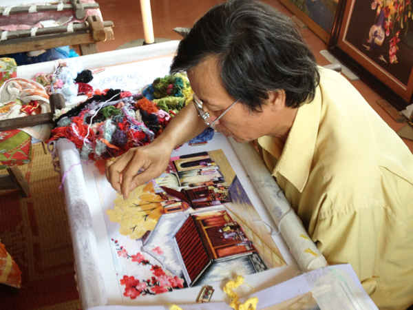    Nghệ nhân Nguyễn Xuân Dục cần mẫn bên khung thêu với những bức tranh thêu tinh xảo