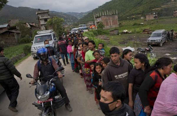 Dân làng Nepal chờ nhận thực phẩm đang được phân phát ở ngoại ô Kathmandu hôm thứ Tư (29/4). Ảnh: BERNAT ARMANGUE / AP