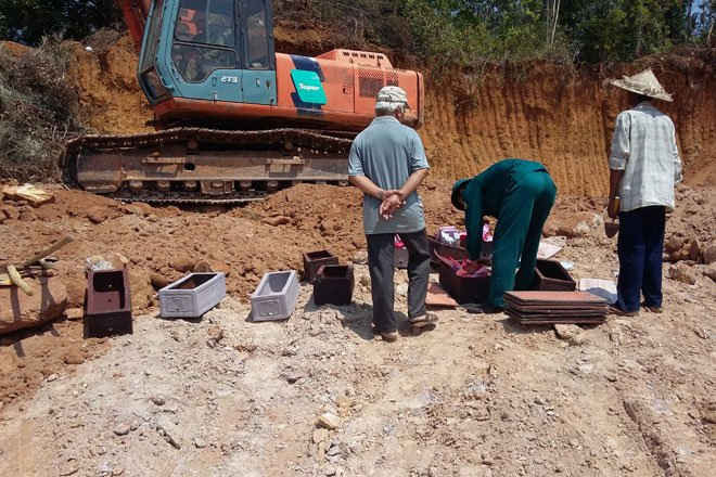 Người dân và chính quyền địa phương chuyển 10 ngôi mộ phát hiện an táng lại gần khu vực đào đất.