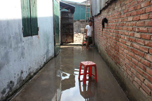 Ông Chu Văn Thảo, đội 1, xã Chàng Sơn, huyện Thạch Thất,TP. Hà Nội xắn quần lội ở ngõ bị ngập nước trước cửa nhà mình