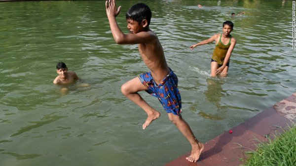    Không chịu được thời tiết nắng nóng, cậu bé Ấn Độ lặn xuống nước để làm mát cơ thể vào hôm thứ Ba (26/5)
