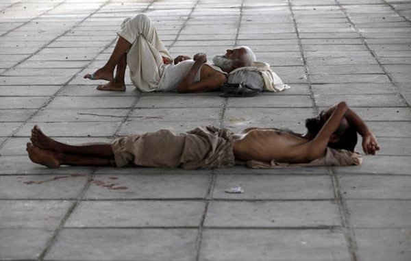 Hai người đàn ông ngủ dưới bóng râm của một cây cầu trong thời tiết nắng nóng dữ dội ở Karachi, Pakistan vào ngày 22/6/2015. Ảnh: REUTERS / Akhtar SOOMRO
