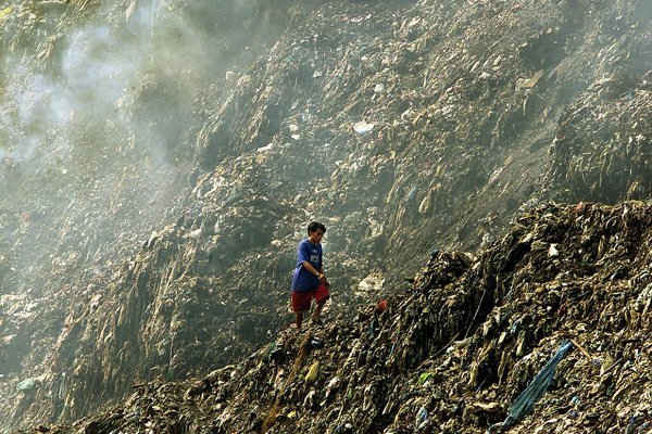 Trong ảnh là người đàn ông đang đi trên một núi rác ở bãi rác Payatas tại thành phố Quezon