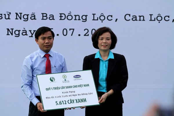 Bà Bùi Thị Hương - Giám đốc Điều hành Vinamilk trao tặng bảng tượng trưng tài trợ cây xanh cho đại diện Ban Giám đốc khu di tích lịch sử Ngã ba Đồng Lộc