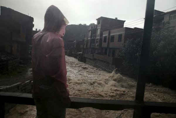  Một người đàn ông đứng nhìn dòng nước lũ trong một trận mưa lớn do ảnh hưởng bởi cơn bão Soudelor tại TP Ninh Đức, tỉnh Phúc Kiến, Trung Quốc vào ngày 9/8. Ảnh: REUTERS / STRINGER