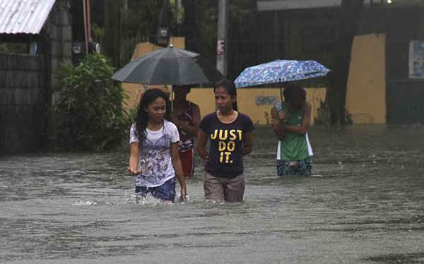  Nhiều người dân phải lội qua nước lũ do siêu bão Goni gây ra tại Bacnotan, La Union, miền bắc Philippines ngày 22/8/2015. Ảnh: REUTERS / TJ Corpuz