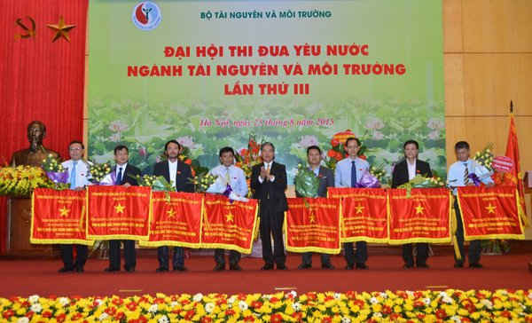 Thừa ủy quyền của Thủ tướng Chính phủ, Bộ trưởng Bộ TN&MT Nguyễn Minh Quang trao Cờ thi đua xuất sắc của Thủ tướng Chính phủ cho các đơn vị có thành tích xuất sắc trong phong trào thi đua ngành TN&MT giai đoạn 2010 - 2015
