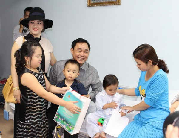 Vợ chồng ông Huỳnh Uy Dũng - bà Nguyễn Phương Hằng thăm và trao quà cho các em bé được mổ tim miễn phí tại Bệnh viện ĐH Y dược TP.HCM. 