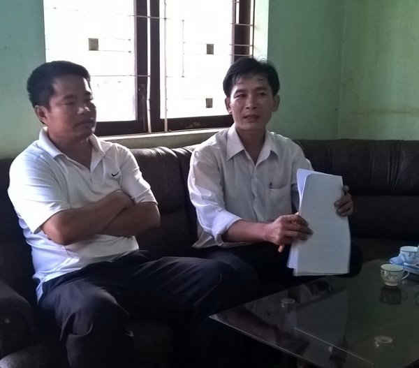 Ông Nguyễn Văn Đường (trái) đang làm việc với cán bộ văn phòng UBND xã Cư Suê, huyện Cư Mgar, tỉnh Đắk Lắk 