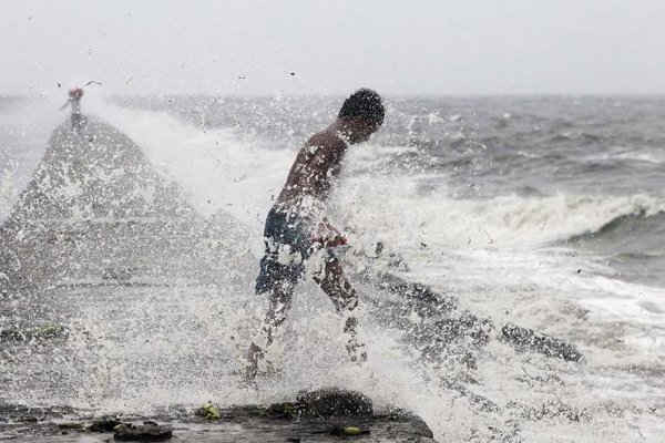  Một cậu bé tìm kiếm các chai nhựa tái sử dụng bị đánh tứ tung bởi sóng do bão Koppu ở vịnh Manila ngày 18 tháng 10 năm 2015 gây ra. Ảnh: Reuters / Romeo Ranoco