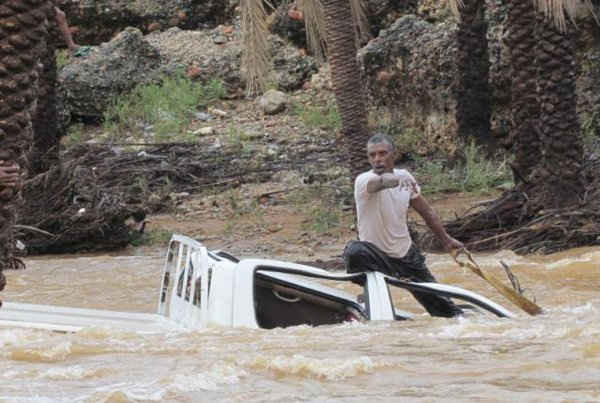  Một người đàn ông chỉ trỏ khi ông cố gắng bảo vệ chiếc xe đang bị dòng nước lũ cuốn đi ở đảo Socotra của Yemen vào ngày 2/11/2015. Ảnh: Reuters / Stringer