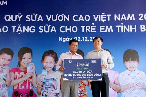 : Ông Đỗ Thanh Tuấn - Trưởng Bộ phận Đối ngoại Vinamilk (bên phải) trao tặng bảng tượng trưng 36.030 ly sữa cho đại diện Quỹ Bảo trợ trẻ em Bến Tre. 