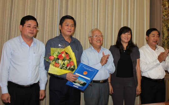 Ông Đào Anh Kiệt, Giám đốc Sở Tài nguyên Môi trường TP (cầm hoa) nhận quyết định thôi giữ chức vụ