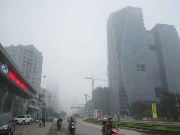 Trên đường Lê Văn Lương, các tòa nhà chìm trong sương mù.
