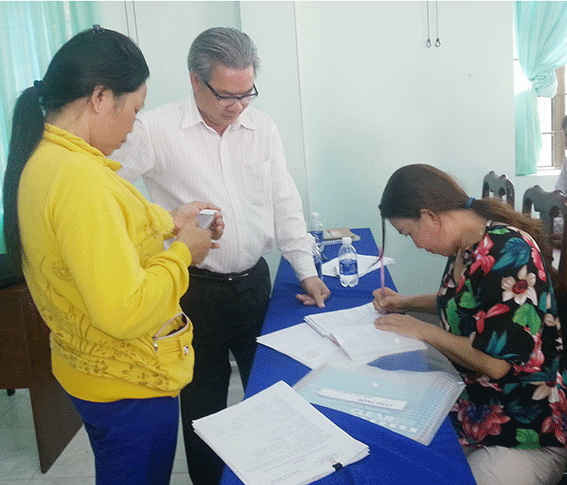 Luật sư Lê Biên Phòng, cộng tác viên Trung tâm trợ giúp pháp lý Nhà nước Sở Tư pháp (giữa) hướng dẫn đại diện các hộ nuôi về thủ tục pháp lý cần thiết khi khởi kiện các DN chế biến hải sản ở Tân Hải.