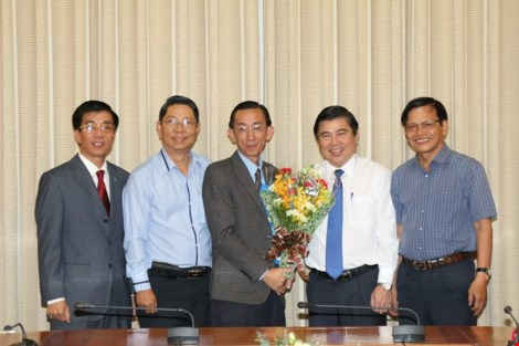 Chủ tịch UBND TP.HCM Nguyễn Thành Phong trao quyết định bổ nhiệm ông Trần Hoàng Ngân (đứng ở giữa). 