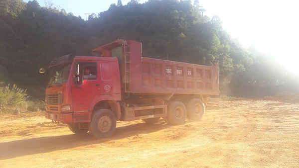 Đoàn xe tải của công ty Hòa Phát, thầu lại của liên doanh nhà thầu, đang xúc đất thải, đổ xuống sông Nậm Rốm. 