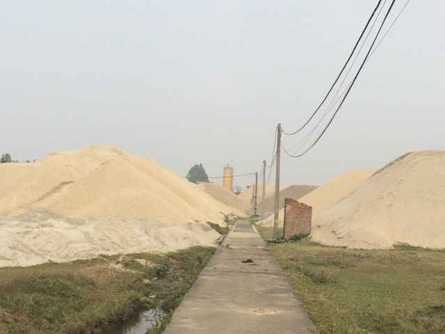 Việc chất tải cát, sỏi xâm lấn hệ thống mương thoát nước, ảnh hưởng tới hành lang đê Sông Hồng đang diễn ra công khai tại Cao Đại.