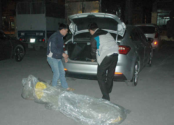 Các đối tượng đang đưa số tang vật bị bắt giữ xuống sân trụ sở Công an Quận Hoàng Mai tối 12/1. Ảnh: Việt Hùng