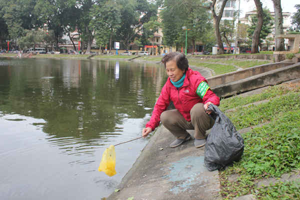 Cô Thúy Lan, đội tự quản Hội phụ nữ phường Nguyễn Du cần mẫn thu gom túi nilon của người dân để lại trên mặt hồ