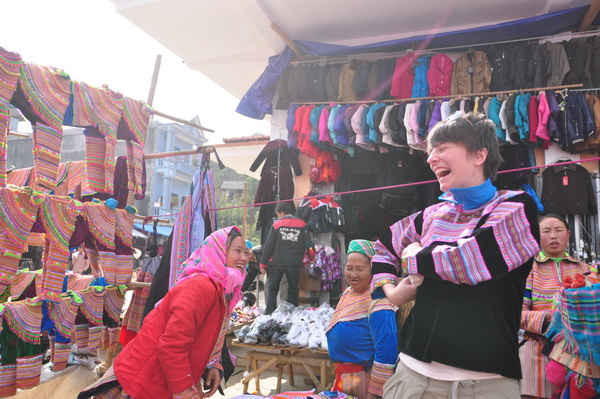 Một nữ du khách chọn được chiếc áo thổ cẩm ưng ý tại chợ phiên vùng cao 