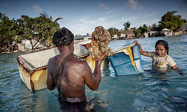  Các thành viên của 1 gia đình thu gom đá và san hô từ đáy biển để xây dựng bức tường đá nhằm bảo vệ chính mình, chống lại nước biển dâng. Người dân Kiribati không tạo ra nhiều lượng phát thải khí nhà kính nhưng họ buộc phải đối mặt với những hậu quả trực tiếp của sự nóng lên toàn cầu. Ảnh: Jonas Gratzer / LightRocket qua Getty Images