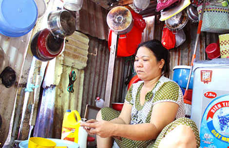 Chị Nguyễn Thị Chung (phường 4, quận 8) trong căn nhà lụp xụp, nơi trú ngụ nhiều thế hệ. 