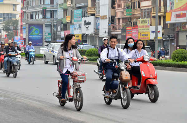 Trên phố Xã Đàn (Hà Nội) các em học sinh khi tan trường về nhà bằng xe máy điện gần như không đội mũ bảo hiểm