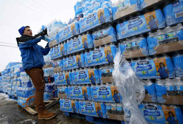 Ngày 5/3/2016, các tình nguyện viên phân phát nước đóng chai, giúp Flint (bang Michigan, Mỹ) chống lại những ảnh hưởng của cuộc khủng hoảng nước do nước uống của thành phố bị ô nhiễm chì tới mức trầm trọng. Ảnh: REUTERS / JIM YOUNG