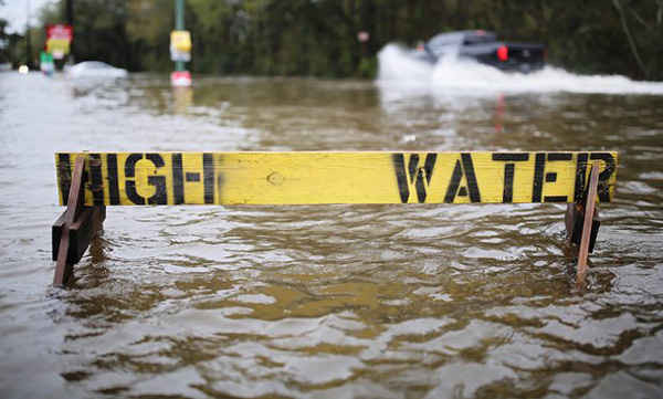 Những chiếc tô lái xe qua con đường ngập lụt sau 1 biển báo Nước cao (High Water) ở Hammond, Louisiana, Mỹ vào ngày 11/3/2016. Khi BĐKH dẫn đến thời tiết khắc nghiệt hơn, nhiều nhà khí tượng học có thể sẽ chú ý. Ảnh: Dan Anderson / EPA