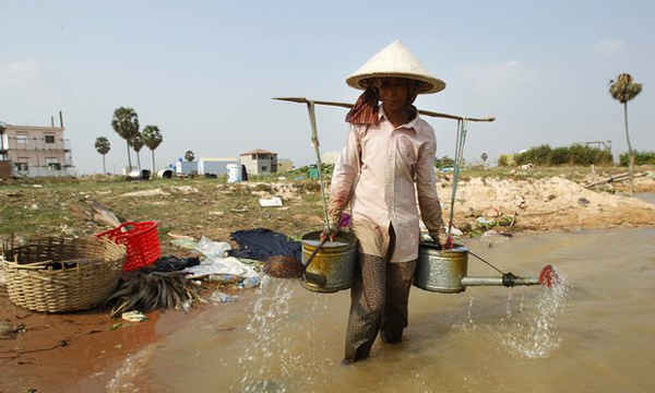 Người nông dân lấy nước tưới cho cây trồng của mình. Phần lớn các nước Đông Nam Á đang hứng chịu đợt hạn hán kỷ lục do hiện tượng El Nino. Ảnh: Heng Sinith / AP