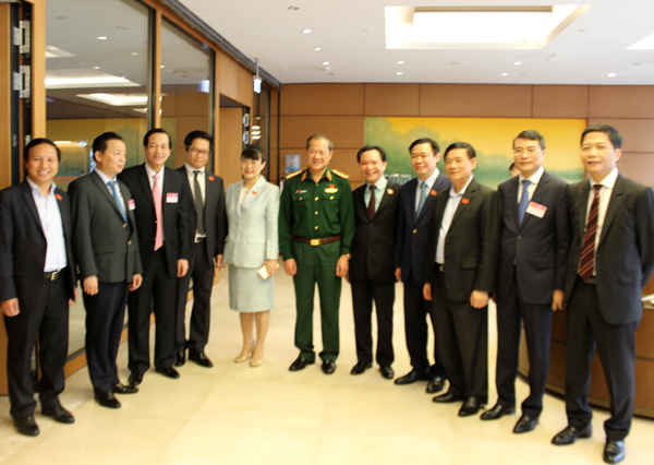 Bộ trưởng Bộ TN&MT Trần Hồng Hà (thứ hai từ trái sang) trao đổi với các đại biểu Quốc hội bên hành lang Quốc hội sáng 09/4. Ảnh: Việt Hùng