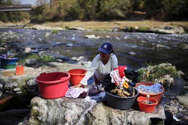 Người phụ nữ giặt quần áo tại sông Acelhuate ở Nejapa, El Salvador vào ngày 23/2/2016. Ảnh: REUTERS / JOSE CABEZAS