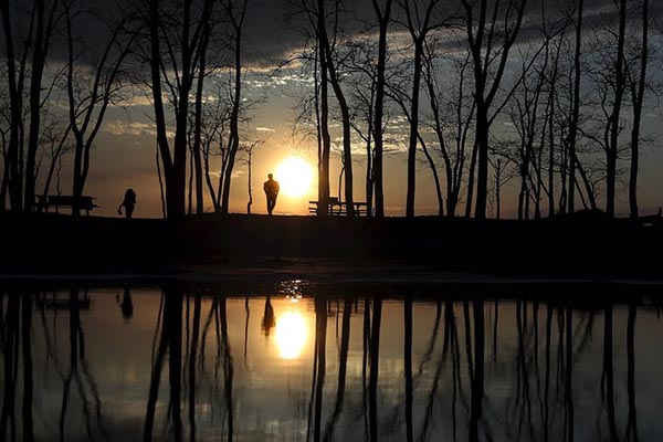 Mọi người ngắm mặt trời lặn ở công viên tiểu bang Presque Isle tại Erie, Pennsylvania. Ảnh: Carlo Allegri / Reuters