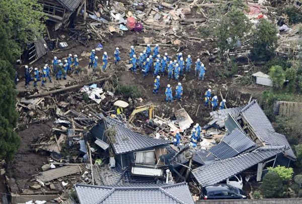 Các nhân viên cứu hộ tiến hành hoạt động tìm kiếm và cứu hộ tại một ngôi nhà bị sụp đổ trong khu vực sạt lở đất do động đất gây ra ở thị trấn Minamiaso, quận Kumamoto, miền nam Nhật Bản vào ngày 16/4/2016. Ảnh: Reuters / Kyodo