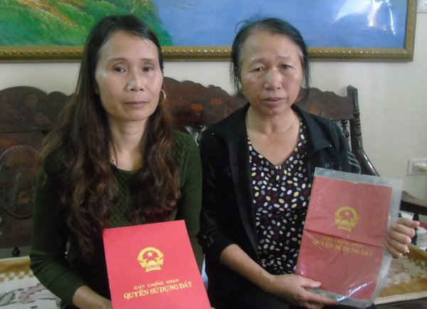 Bà Hiền (bên phải) cầm sổ đỏ của mẹ bà là cụ Hữu