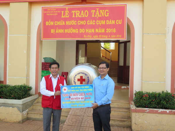 Đại diện Hội Chữ thập đỏ tỉnh Bình Phước trao tặng tượng trưng bồn chứa nước sạch cho lãnh đạo huyện Bù Đốp