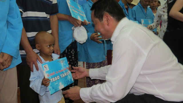 Ông Trương Gia Bình- Chủ tịch HĐQT Tập đoàn FPT trao tiền hỗ trợ cho các bệnh nhân nghèo