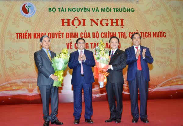 Đồng chí Phạm Minh Chính - Ủy viên Bộ Chính trị, Bí Thư Trung ương Đảng - Trưởng Ban Tổ chức Trung ương (thứ hai bên trái) trao Quyết định và tặng hoa cho Bộ trưởng Trần Hồng Hà và nguyên Bộ trưởng Nguyễn Minh Quang
