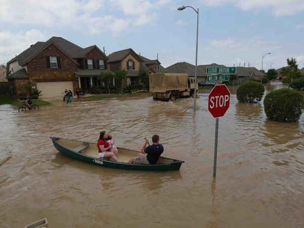Một người phụ nữ bế đứa con ngồi trên một chiếc xuồng khi vệ binh của Texas đến trợ giúp người dân sau trận lũ lụt ở Brookshire, Texas, Mỹ vào ngày 20/4/2016