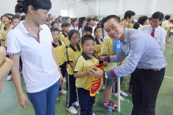 Ông Trương Văn Toàn, Giám đốc Đối ngoại và Pháp Lý Công ty FrieslandCampina VN trao Cờ lưu niệm cho các học sinh tham gia Ngày Hội 