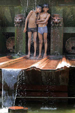 Trẻ em tắm mát tại một đài phun nước ở Delhi. Ảnh: Harish Tyagi / EPA