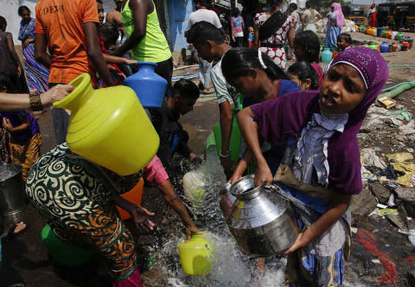 Cư dân lấy nước từ một công trường xây dựng tại khu ổ chuột ở Mumbai. Ảnh: Rajanish Kakade / AP