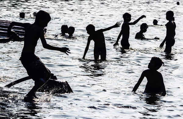 Những đứa trẻ tắm trong một hồ bơi cạn trong khu vườn gần Cổng Thành Ấn Độ (India Gate), Delhi. Ảnh: Roberto Schmidt / AFP / Getty Images