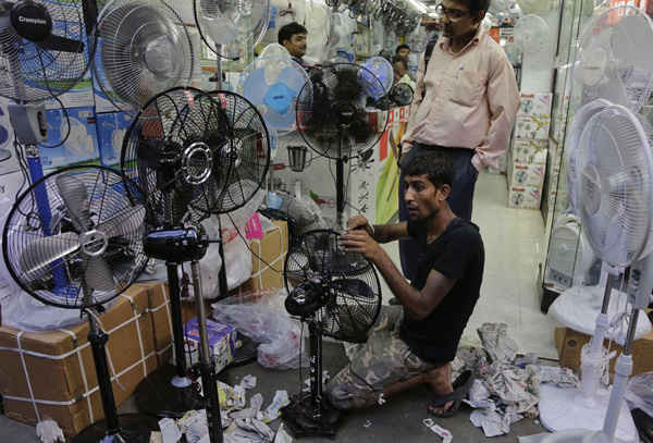 Nhân viên lắp ráp những chiếc quạt tại một cửa hàng ở Kolkata. Ảnh: Bikas Das / AP